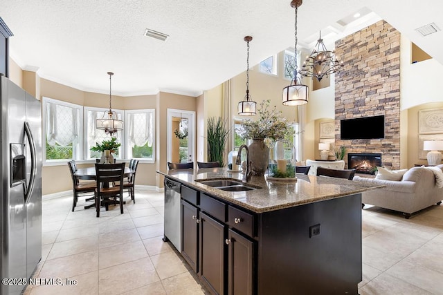 kitchen with visible vents, appliances with stainless steel finishes, a sink, and a stone fireplace