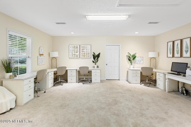 carpeted office featuring a textured ceiling, visible vents, and recessed lighting