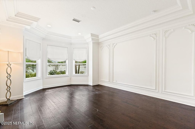 empty room with ornamental molding, dark wood-style flooring, visible vents, and baseboards