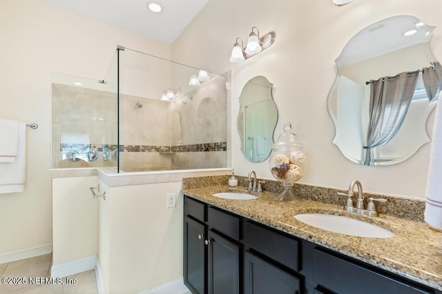 bathroom featuring tile patterned floors, double vanity, a sink, and a walk in shower