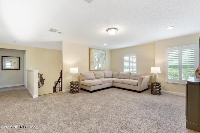 carpeted living room with visible vents, baseboards, a textured ceiling, and recessed lighting