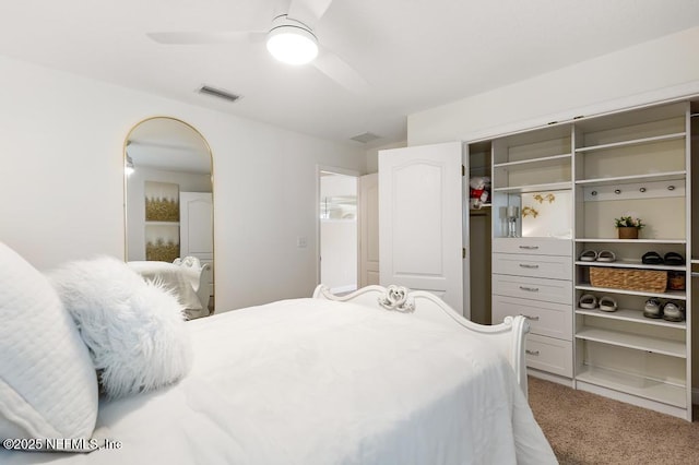 carpeted bedroom with ceiling fan, visible vents, and a closet