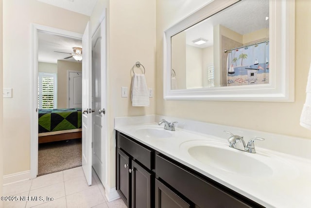 bathroom featuring double vanity, tile patterned flooring, baseboards, and a sink