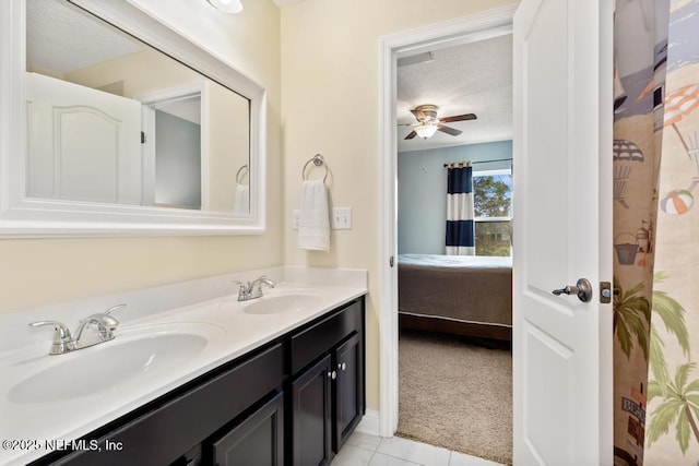 ensuite bathroom with connected bathroom, a sink, a textured ceiling, and double vanity