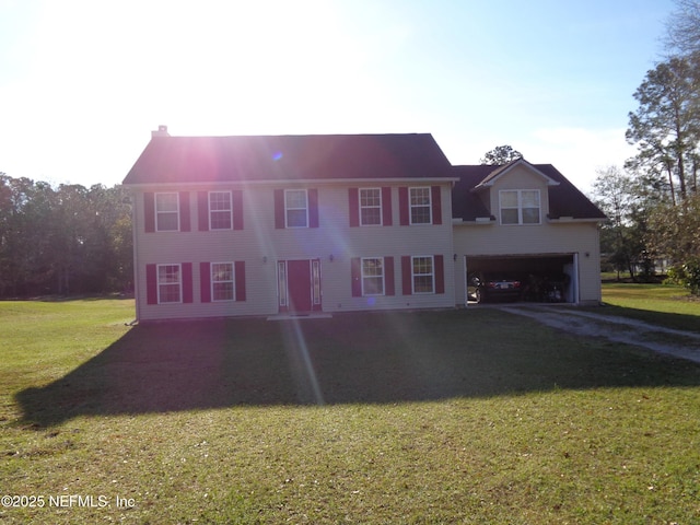 colonial house featuring a front yard, driveway, and an attached garage