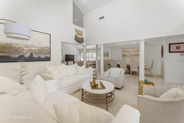 tiled living area with a towering ceiling, ornate columns, baseboards, and visible vents