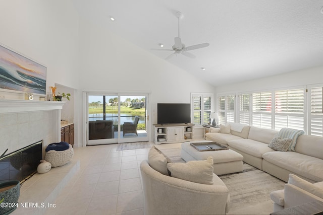 living area featuring ceiling fan, high vaulted ceiling, light tile patterned flooring, recessed lighting, and a fireplace