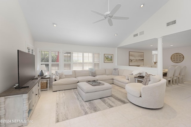 living area featuring light tile patterned floors, high vaulted ceiling, visible vents, a ceiling fan, and decorative columns