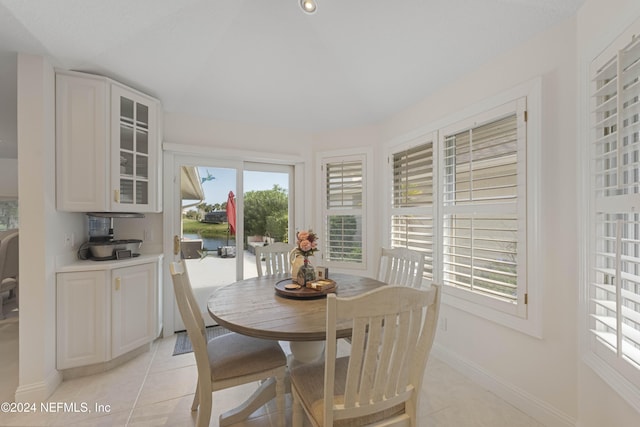 dining space featuring light tile patterned flooring and baseboards