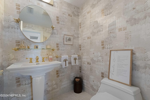 half bath featuring visible vents, wallpapered walls, toilet, and tile patterned floors