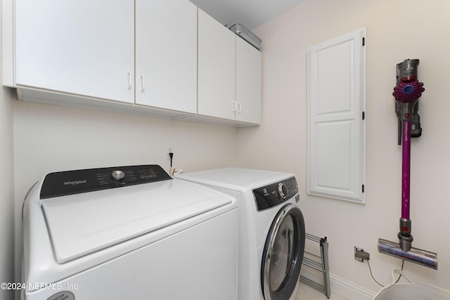 laundry room with baseboards, cabinet space, and washing machine and clothes dryer