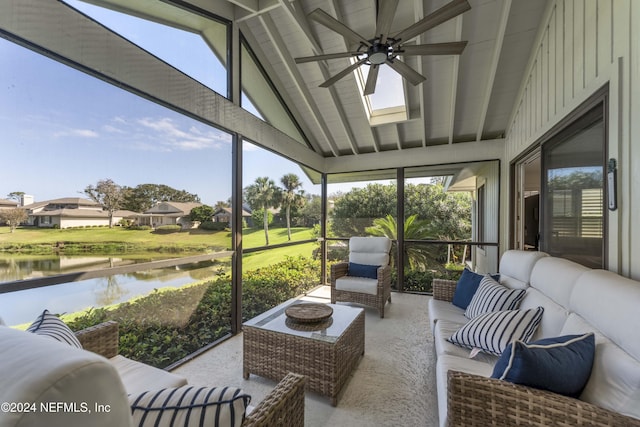 sunroom with a ceiling fan, a water view, plenty of natural light, and lofted ceiling with skylight