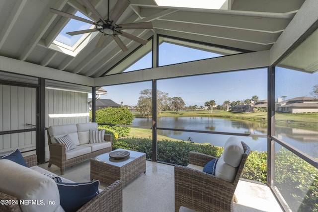 sunroom featuring a water view, vaulted ceiling with skylight, and a ceiling fan