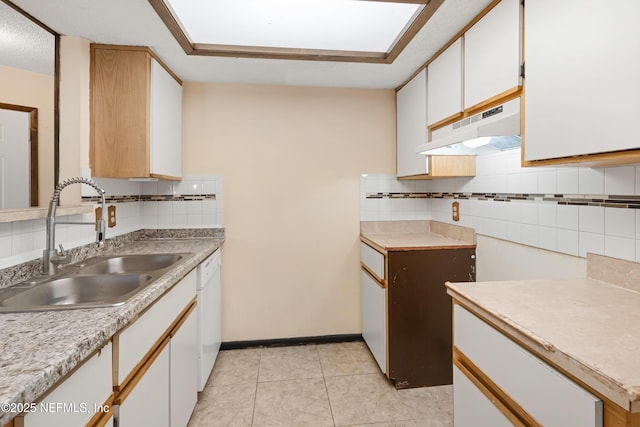 kitchen with light tile patterned floors, dishwasher, light countertops, under cabinet range hood, and a sink