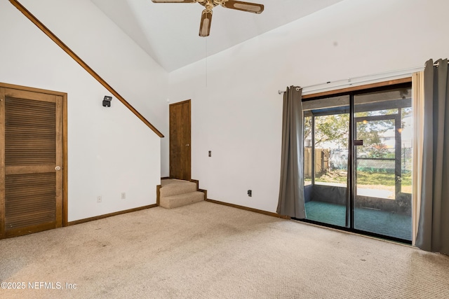 interior space with stairway, ceiling fan, baseboards, and high vaulted ceiling