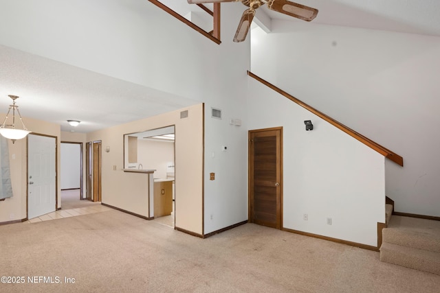 unfurnished living room featuring baseboards, a ceiling fan, visible vents, and light colored carpet