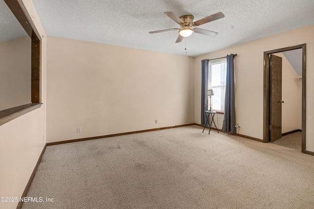 unfurnished room featuring carpet floors, a textured ceiling, baseboards, and a ceiling fan