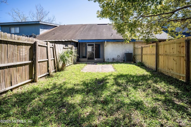 rear view of house with a yard, roof with shingles, cooling unit, and a fenced backyard