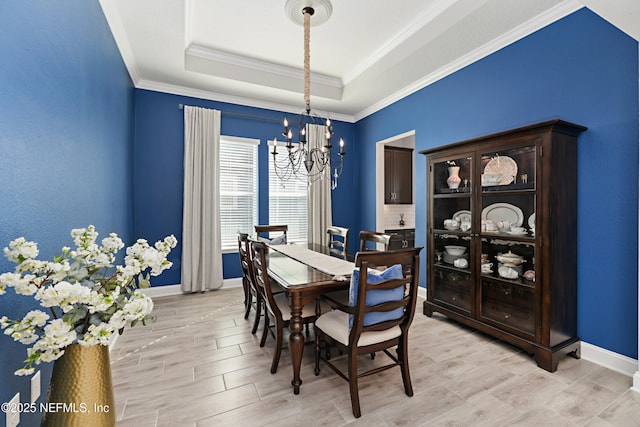 dining room with baseboards, a raised ceiling, a chandelier, and wood tiled floor