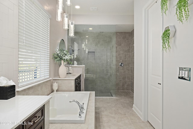 full bathroom featuring vanity, a garden tub, a walk in shower, and tile patterned floors