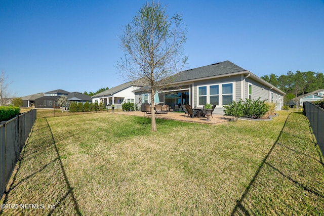 back of property featuring a yard, a fenced backyard, and a patio area