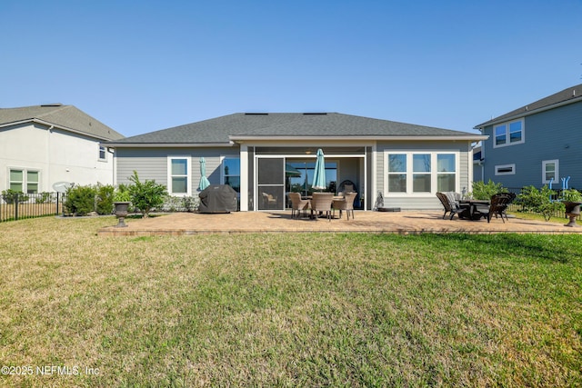 rear view of property featuring a lawn, a patio, and fence