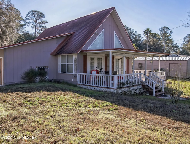 view of front of home with a front yard, metal roof, and french doors