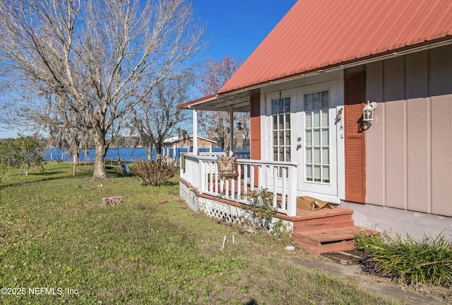 view of yard featuring french doors and a water view