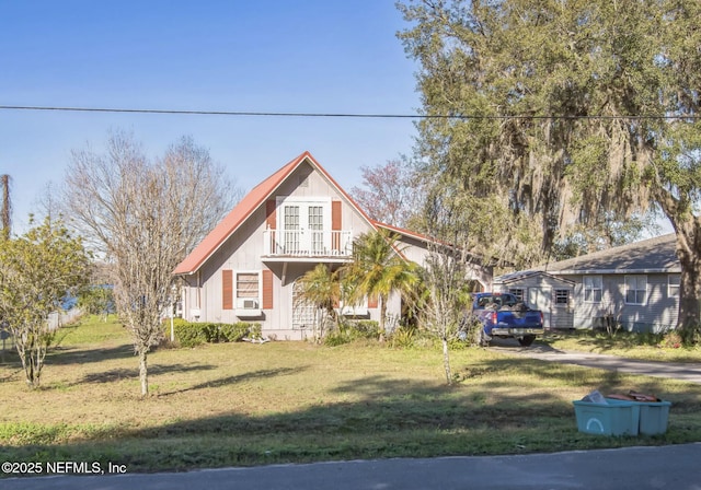 view of front of home featuring a front yard and a balcony