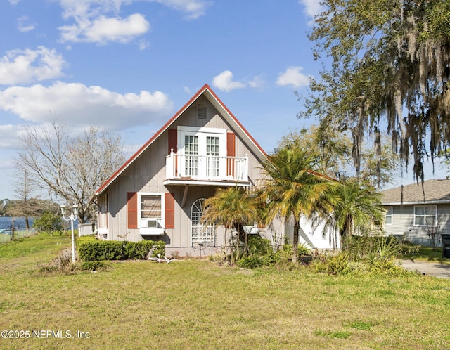 view of front of property featuring cooling unit, a balcony, and a front lawn