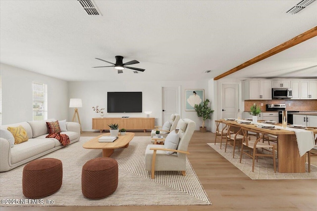 living area featuring a ceiling fan, light wood-type flooring, and visible vents