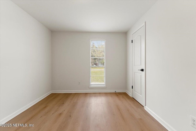 empty room featuring light wood-type flooring and baseboards