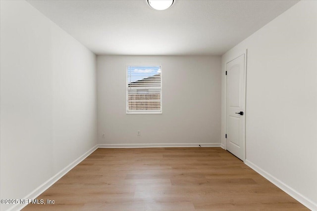 spare room featuring light wood-style flooring and baseboards