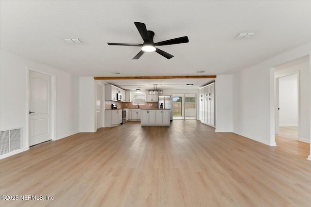 unfurnished living room featuring light wood-type flooring, visible vents, and ceiling fan