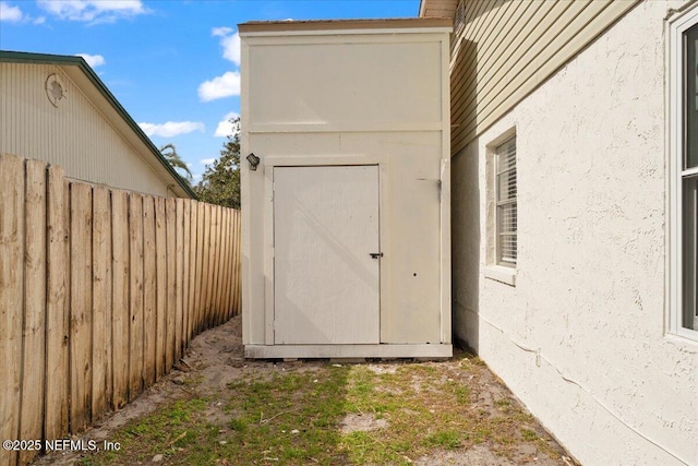 view of shed featuring fence