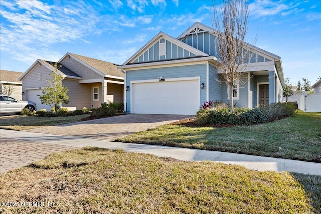 view of front of house with board and batten siding, an attached garage, decorative driveway, and a front yard