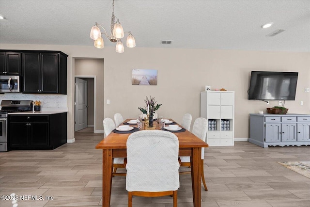 dining room featuring a chandelier, visible vents, baseboards, and wood tiled floor