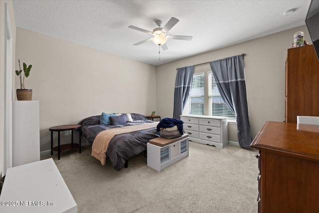 bedroom with a textured ceiling, ceiling fan, and light carpet