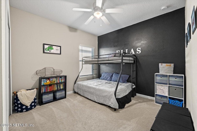 carpeted bedroom featuring a textured ceiling, baseboards, and a ceiling fan