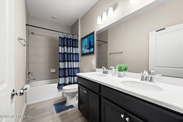 full bathroom featuring a textured ceiling, toilet, shower / tub combo with curtain, and a sink