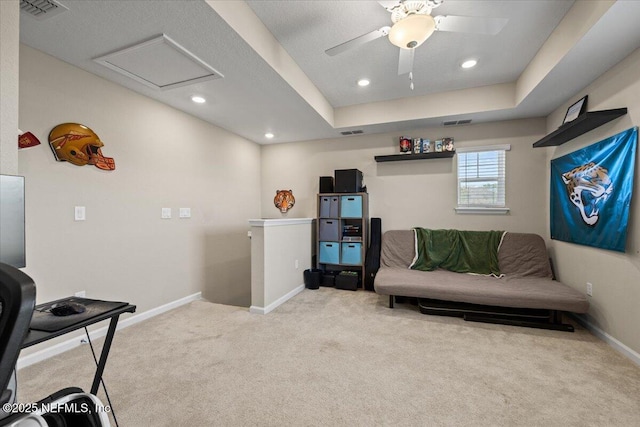 sitting room with visible vents, baseboards, attic access, carpet floors, and an upstairs landing