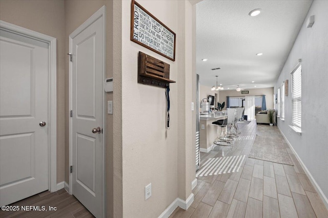 corridor with recessed lighting, baseboards, and wood finish floors