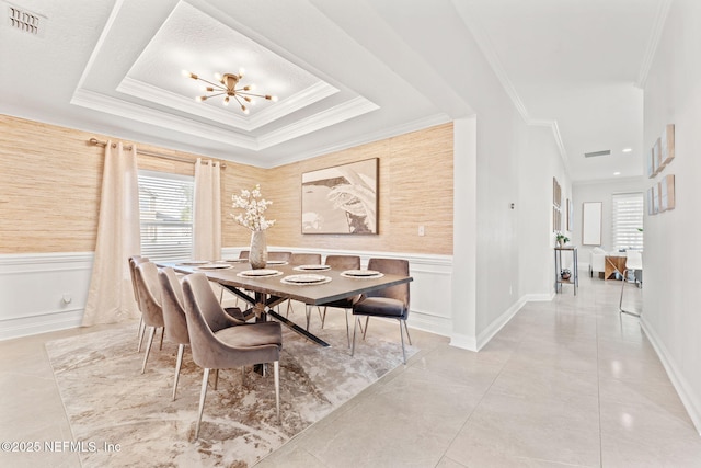 dining area with a raised ceiling, crown molding, and visible vents