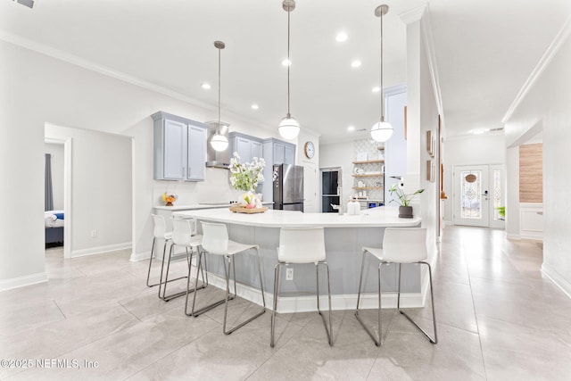 kitchen featuring a kitchen breakfast bar, ornamental molding, light countertops, and freestanding refrigerator