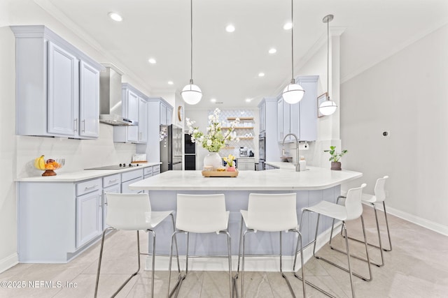 kitchen featuring a breakfast bar, a peninsula, refrigerator, wall chimney exhaust hood, and backsplash