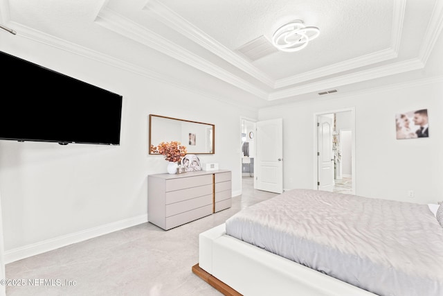 bedroom with a tray ceiling, baseboards, visible vents, and crown molding