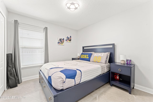 bedroom featuring baseboards and a textured ceiling