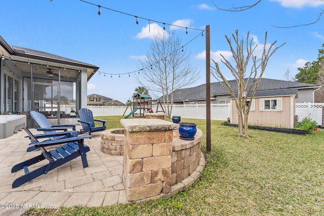 view of yard with a playground, a patio, a fenced backyard, a sunroom, and a ceiling fan