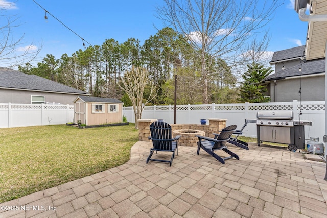 view of patio / terrace featuring a fenced backyard, a fire pit, an outdoor structure, and a storage shed