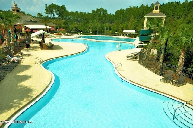 community pool featuring a patio and fence